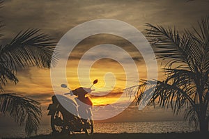 A motorbike on the background of an orange sunset by the sea. A serene holiday in Thailand, relaxation. Tourism and