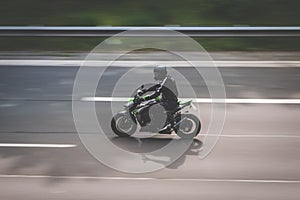 Motorbike driving fast on highway , motion blur