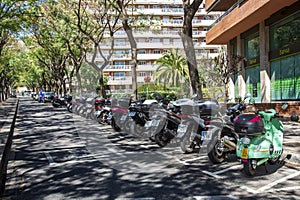 Motorbike group parking on urban greening and quiet street