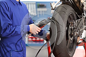 Motorbike mechanic checking tires air pressure