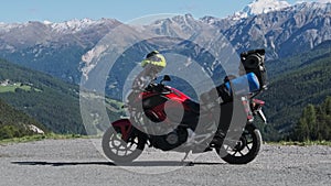 Motorbike with Motorcycle Cases Stands Against Mountain Landscape of Swiss Alps