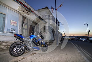 Motorbike near derelict building with sunset