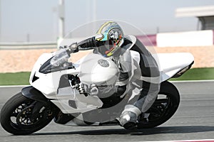 Motorbike on racetrack, leaning into sharp bend