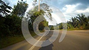 Motorbike road riding POV time lapse. Country road thru rural landscape with amazing high cliff mountains. Khao Sok