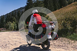 Motorbiker back view, in action, summer day, motorcycle off road, the driver with adventure, touring motorbike with side bags,