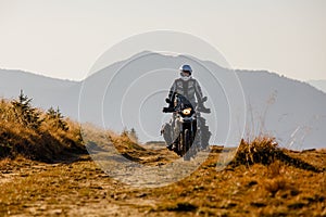 Motorbiker travelling in autumn mountains