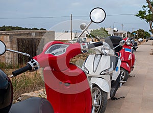 Motorbikes parked on the side of the road  popular and easiest way for transport in Formentera photo