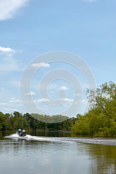 Motorboat on calm river during a bright sunny day