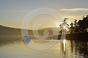 Motorboat exiting Conover Cove at sunset, Wallace Island, Gulf Islands, British Columbia