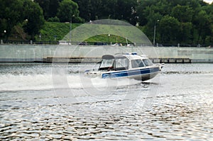 Motorboat racing through the river. Boat police of Russia floating on the Moscow river. Police boat rushing on water surface