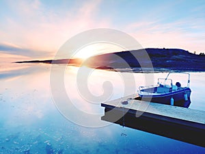 Motorboat for sport fishing tied to a wooden floating dock. Fishing boat in bay port,