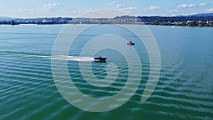 Motorboat and Wakeboard driving on Lake Zurich, Switzerland. Summer Watersport drone aerial shot with cloudy sky