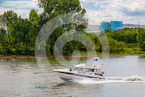 A motorboat in white and blue cruising with high speed on the river Rhine in Germany