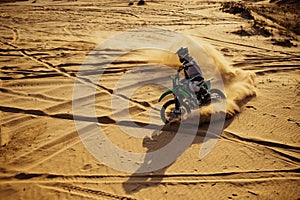 Motorcross riding over sand in desert dune