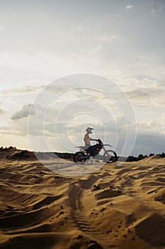 Motorcross riding over sand in desert dune