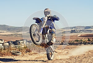 Motorcycle, action and balance of person with speed and skill for adrenaline and stunt with extreme sports outdoor