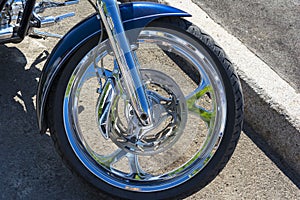 Motorcycle brake disc on the front wheel, brake caliper and tire, shining chrome