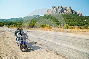 Motorcycle with camping equipment on a mountain dirt road