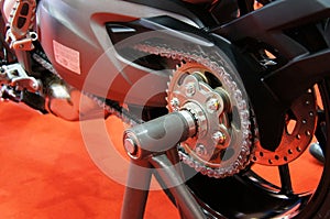 Motorcycle chain. It is a metallic chain that is used to transmit power from the engine to the rear wheel.