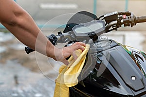 Motorcycle clean, youngman hand with yellow fabric washing a motorcycle