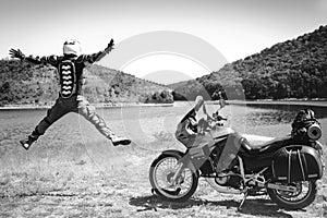 Motorcycle driver jump with his arms outstretched. for a meeting of adventures on the dirt beach mountain river, enduro, off road