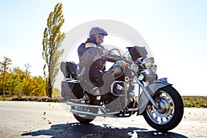 Motorcycle Driver Riding Custom Chopper Bike on Autumn highway. Adventure Concept.