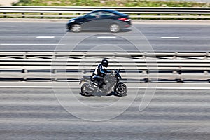 A motorcycle fast driving on motorway, side view