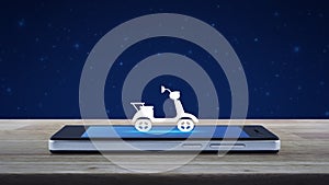 Motorcycle flat icon on modern smart mobile phone screen on wooden table over fantasy night sky and moon, Business delivery servic
