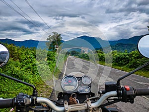 Motorcycle front view at tarmac road with mountain view at morning