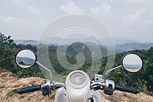 Motorcycle handlebars with Laotian mountains on background