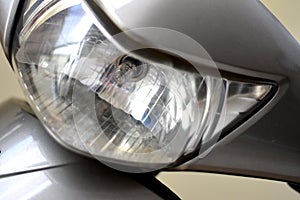 Motorcycle headlight close-up, front view, detail, focusing on headlight, selective focus, zoomed photo.