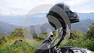 Motorcycle and helmet close up in mountain and cloudy sky