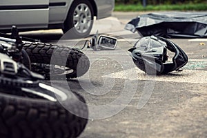 Motorcycle and helmet on the street after dangerous traffic incident photo