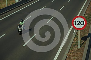 Motorcycle on highway and SPEED LIMIT signpost in Madrid photo