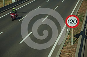 Motorcycle on highway and SPEED LIMIT signpost in Madrid photo
