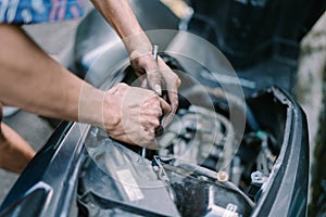 A motorcycle mechanic is checking a damaged engine