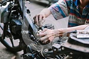 A motorcycle mechanic is checking a damaged engine