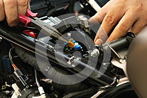 Motorcycle mechanic replaces a fuse battery. motorcycle maintenance and service and repair concept , selective focus