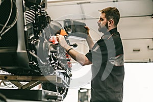 Motorcycle mechanic replacing and pouring fresh oil into engine