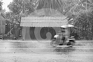 Motorcycle motion riding through gale rain on front wooden house