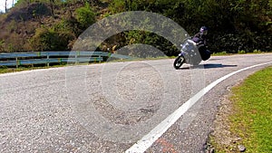 Motorcycle ridding in himalayan mountain twisty road at morning from low angle