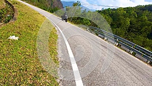 Motorcycle ridding in himalayan mountain twisty road at morning from low angle