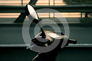 Motorcycle scooter.scooter with headlight, handlebar and mirrors against blue sky. Against the background of the setting sun