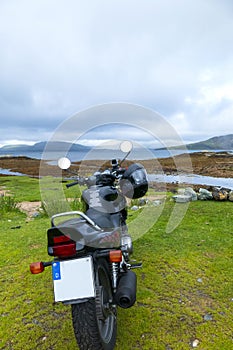 Motorcycle stands on the coast of Loch Eishort, Ord, Isle of Skye, Guillin Mountains in Background photo