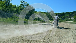 Motorcycle starts the movement. Wheel of motocross bike starting to spin and kicking up ground or dirt. Slow motion
