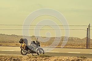 Motorcycle with traveling baggage parked by the roadside in sandstorm weather