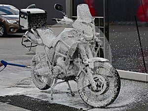 Motorcycle washing with cleaning foam. Pure moto bike. Enduro motorcycle. Cleanliness of vehicles. Car wash professional