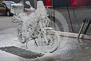 Motorcycle washing with cleaning foam. Pure moto bike. Enduro motorcycle. Cleanliness of vehicles. Car wash professional