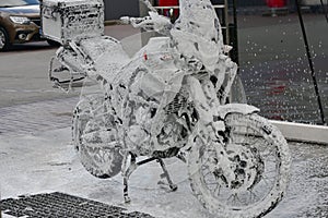 Motorcycle washing with cleaning foam. Pure moto bike. Enduro motorcycle. Cleanliness of vehicles. Car wash professional