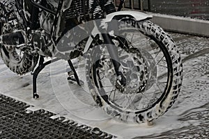 Motorcycle washing with cleaning foam. Pure moto bike. Enduro motorcycle. Cleanliness of vehicles. Car wash professional